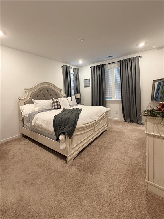 117 Red Maple Way Adairsville, GA 30103 - Photo 26 of 44 a spacious bedroom with a bed a couch and a flat tv screen on wall