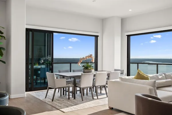 a living room with stainless steel appliances kitchen island granite countertop a sink and a refrigerator