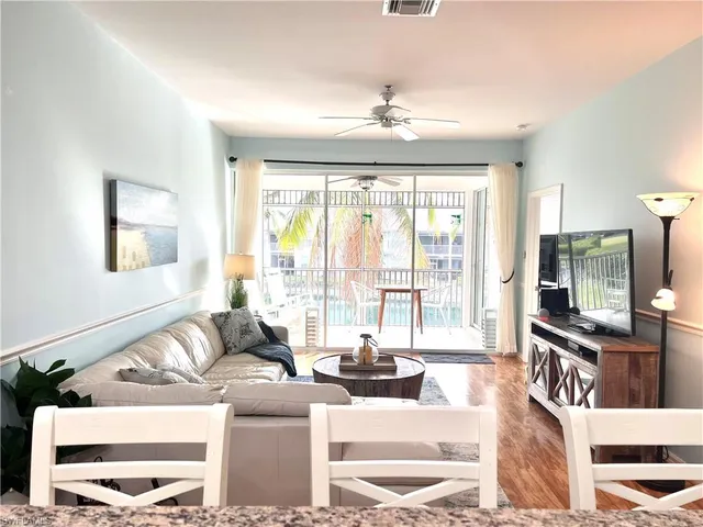 a living room with furniture a flat screen tv and a large window