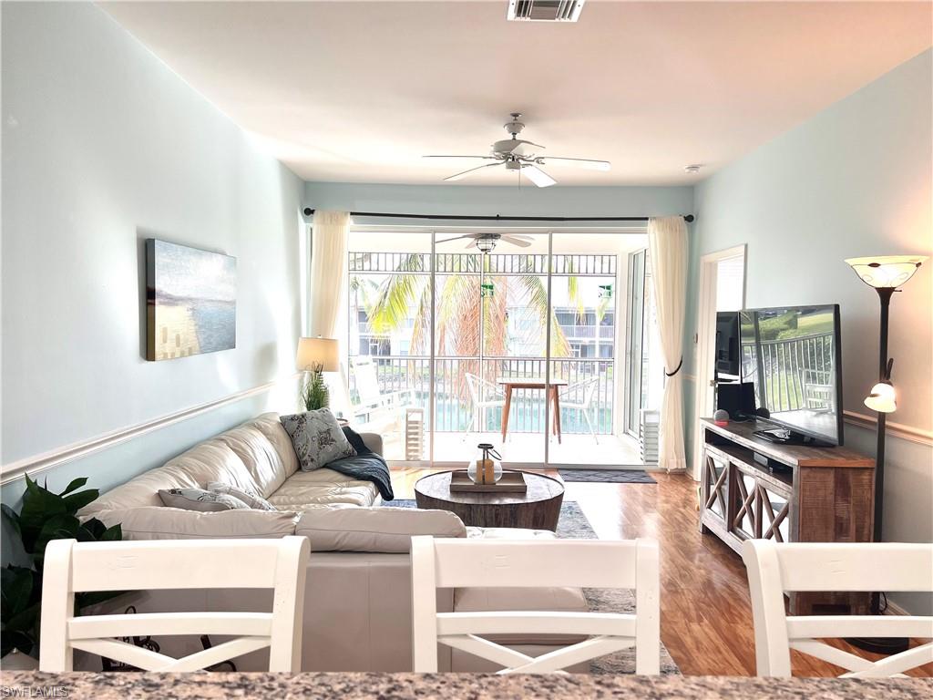 7880 Mahogany Run Lane, Unit 1623 Naples, FL 34113 - Photo 6 of 22 a living room with furniture a flat screen tv and a large window