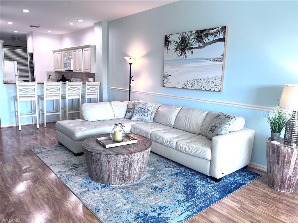 7880 Mahogany Run Lane, Unit 1623 Naples, FL 34113 - Photo 8 of 22 a living room with furniture and a wooden floor