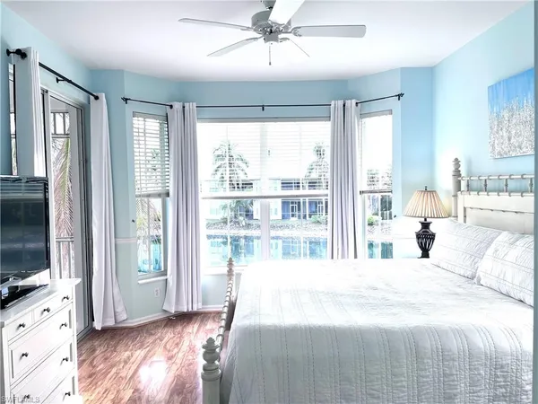 a bedroom with a large bed and a flat tv screen