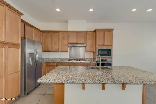 a kitchen with stainless steel appliances granite countertop a sink stove and refrigerator