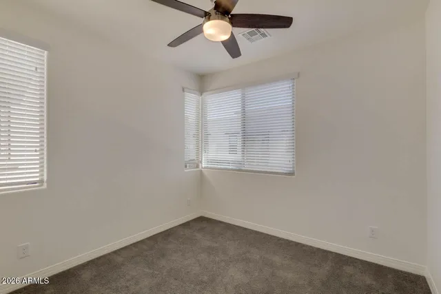 an empty room with a window and a fan