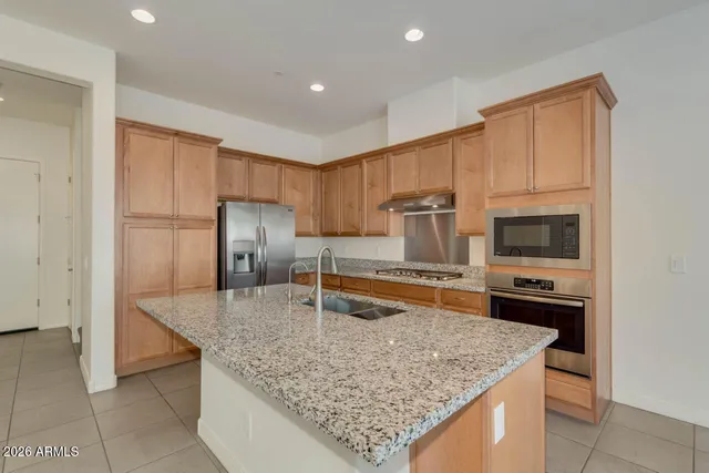 a kitchen with stainless steel appliances granite countertop a sink stove and refrigerator