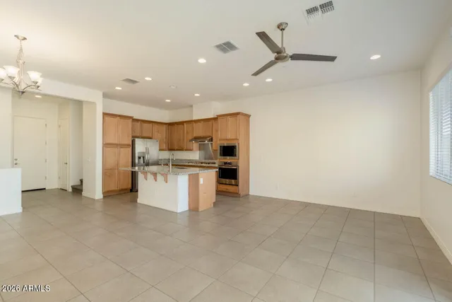 a view of kitchen with stainless steel appliances kitchen island granite countertop a refrigerator and a stove top oven