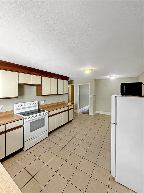 109 Hampshire Road, Unit 2 Methuen, MA 01844 - Photo 5 of 29 a kitchen with stainless steel appliances a stove a sink and a refrigerator