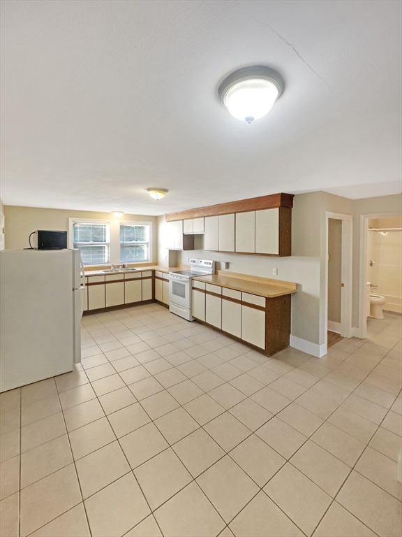 109 Hampshire Road, Unit 2 Methuen, MA 01844 - Photo 6 of 29 a large white kitchen with a sink and cabinets