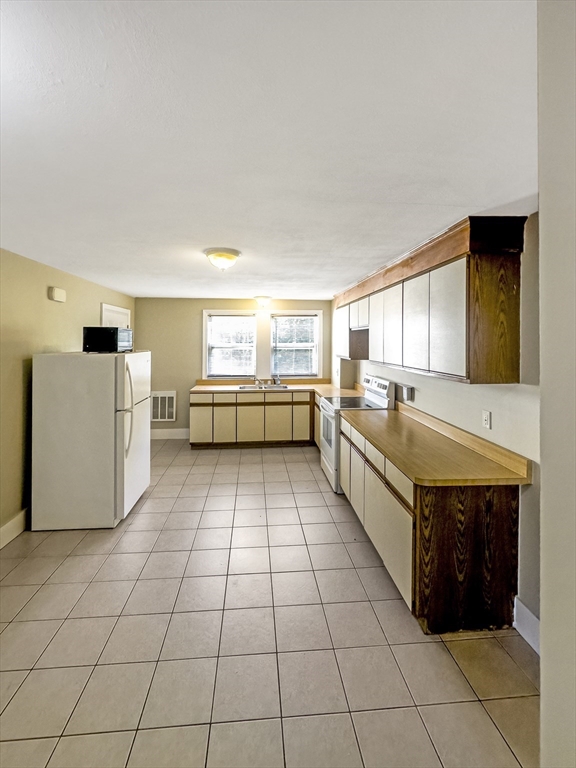 109 Hampshire Road, Unit 2 Methuen, MA 01844 - Photo 8 of 29 a large kitchen with a cabinets and white checkered floor