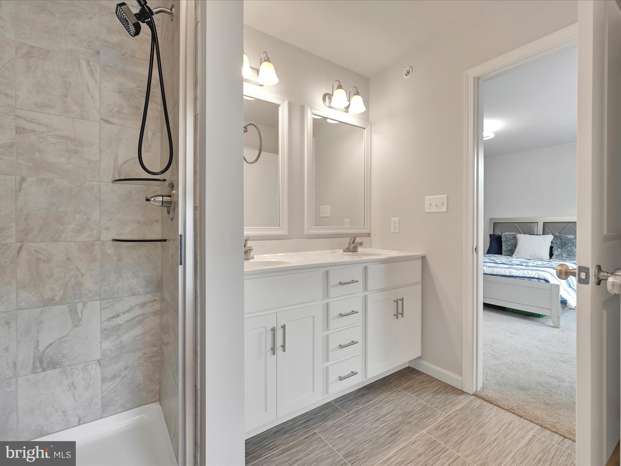 108 Staplehill Court Sinking Spring, PA 19608 - Photo 23 of 33 a spacious bathroom with a double vanity sink a large mirror and shower