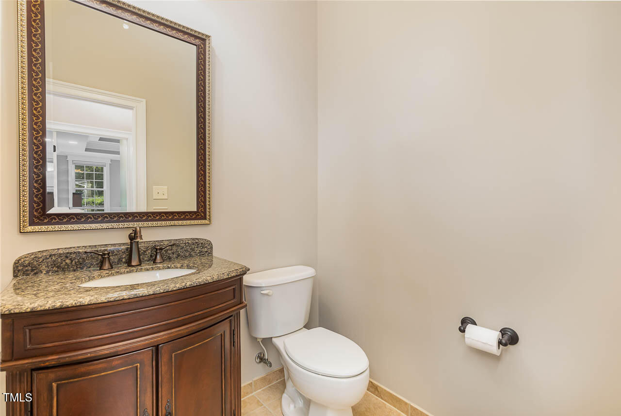 1097 Tacketts Pond Drive Raleigh, NC 27614 - Photo 12 of 38 a bathroom with a granite countertop toilet sink and mirror