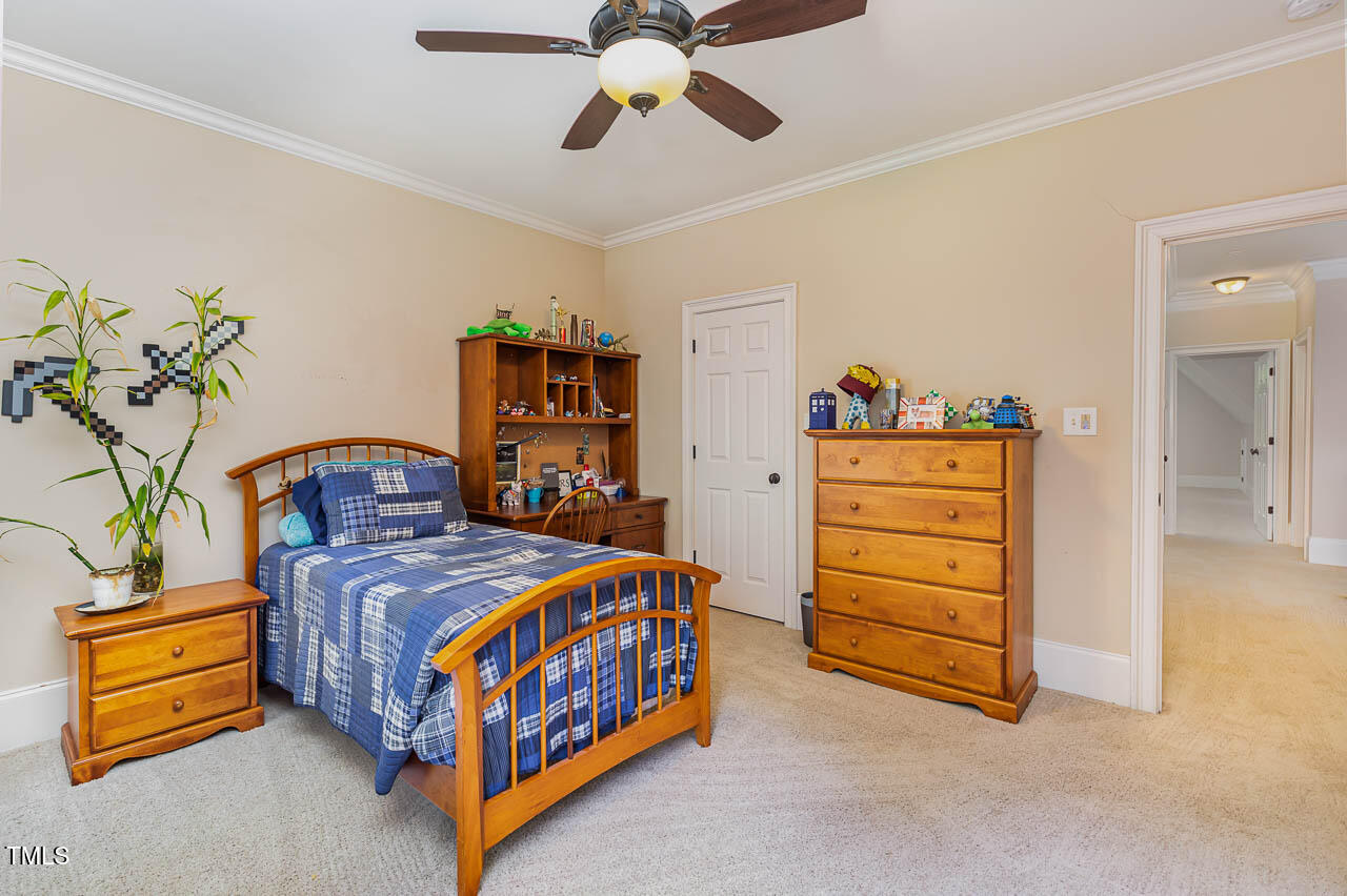1097 Tacketts Pond Drive Raleigh, NC 27614 - Photo 24 of 38 a bedroom with a bed and a chandelier
