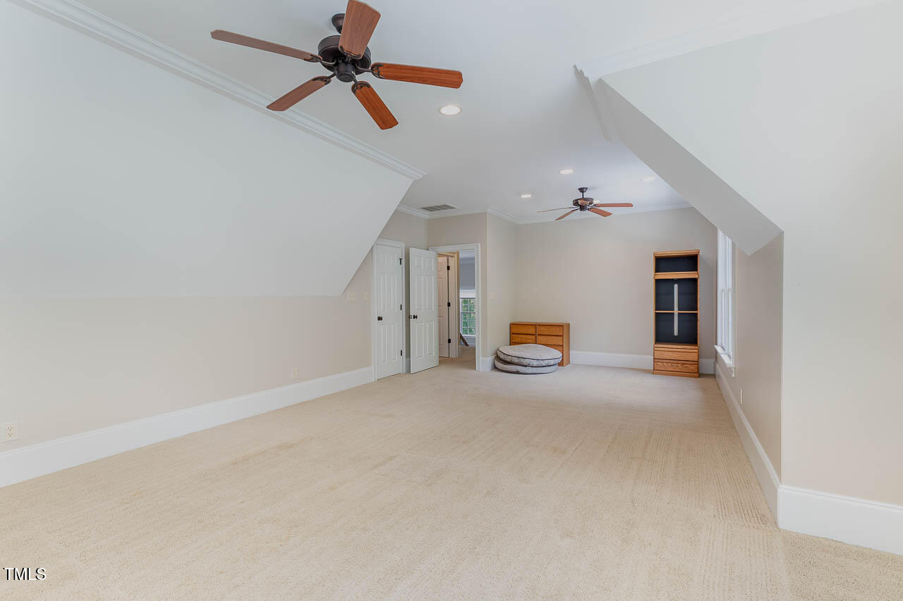 1097 Tacketts Pond Drive Raleigh, NC 27614 - Photo 27 of 38 an empty room with chandelier fan and windows