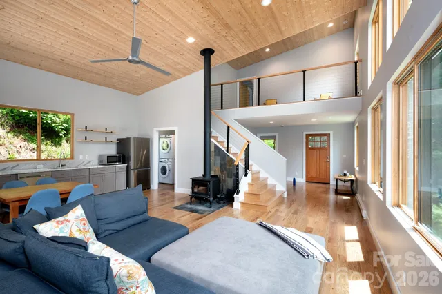 a view of an empty room with wooden floor and furniture