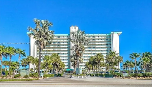 a living room with furniture and a lamp on table with wooden floor