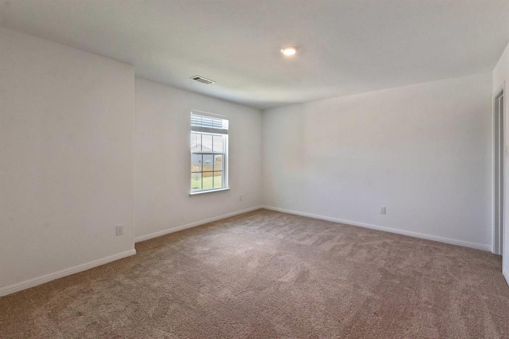 16429 Farmhouse Lane Elgin, TX 78621 - Photo 16 of 22 Spacious room with plush carpeting, neutral wall finishes, and a window with blinds