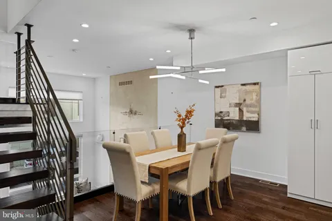 a kitchen with a table chairs and white cabinets