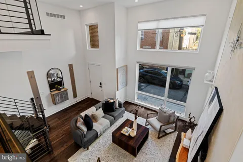 a kitchen with stainless steel appliances a stove a sink dishwasher and a dining table with wooden floor