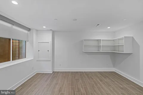 a view of empty room with wooden floor