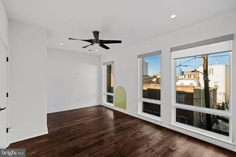 a view of hallway with stairs and wooden floor