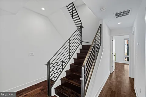 a spacious bathroom with double sink a toilet a mirror and shower