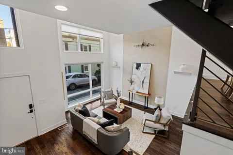 a dining room with furniture entryway and wooden floor