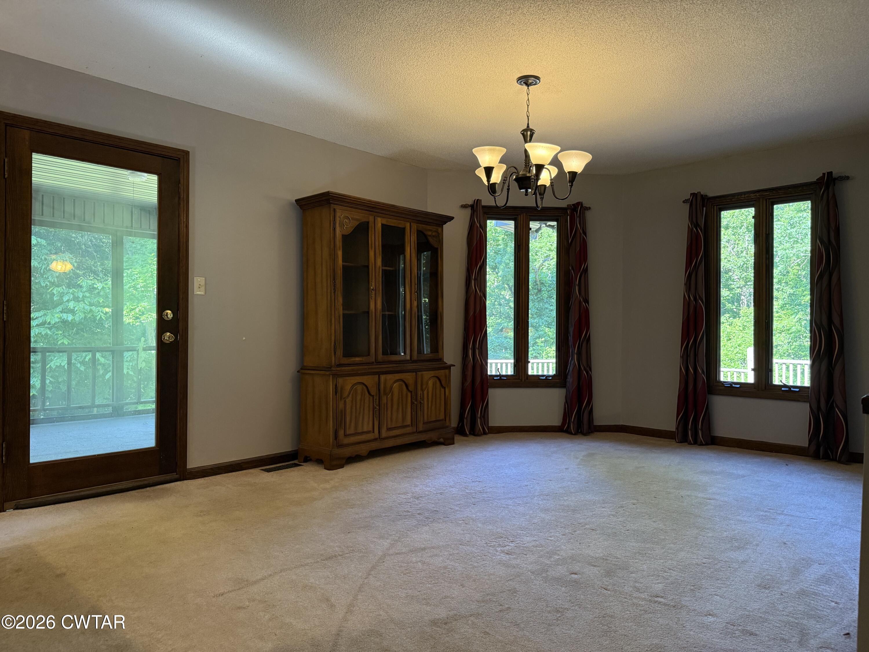 930 Oak Ridge Road Dyersburg, TN 38024 - Photo 19 of 59 an empty room with windows and chandelier