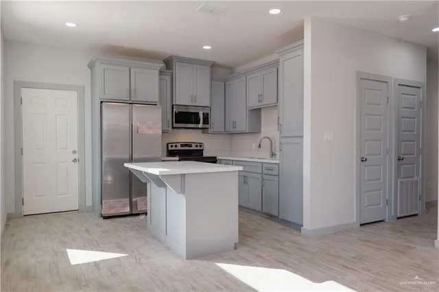 a kitchen with a refrigerator sink and white cabinets