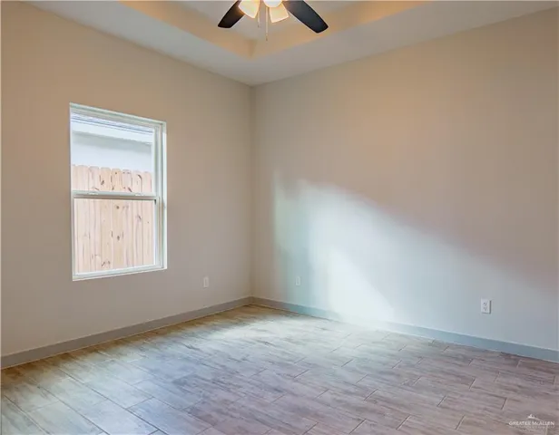 an empty room with a window and a ceiling fan