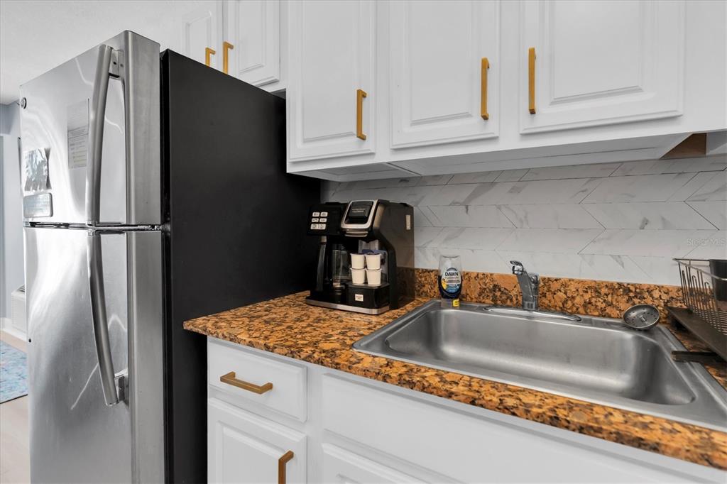 16333 Gulf Boulevard, Unit 217 St. Petersburg, FL 33708 - Photo 13 of 30 a kitchen with stainless steel appliances granite countertop a refrigerator and a sink