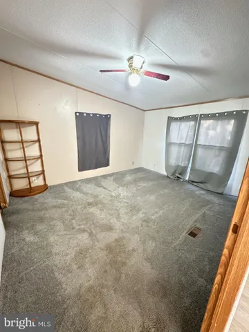 en empty room with windows and fan