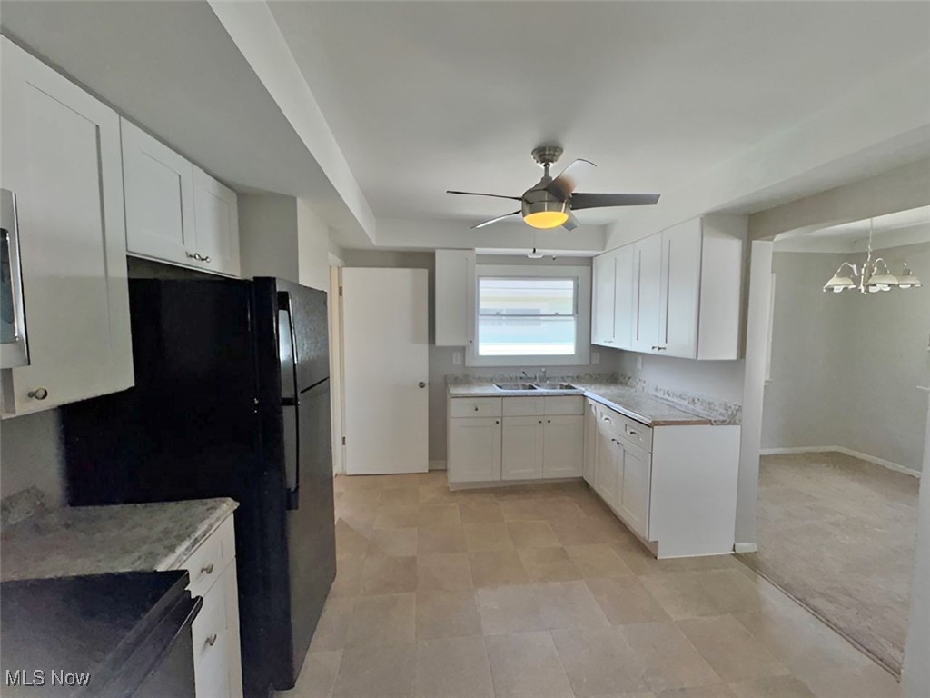 28642 Forest Road Willowick, OH 44095 - Photo 9 of 23 Kitchen with stainless steel stove, a ceiling fan, white cabinetry, a chandelier, and hanging light fixtures