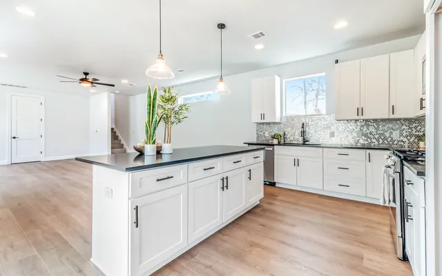 a kitchen with granite countertop white cabinets white appliances with a sink and dishwasher