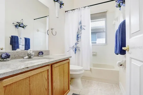 a bathroom with a granite countertop sink a toilet and shower