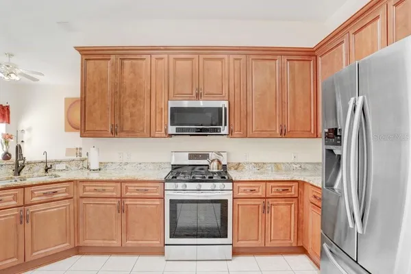 a kitchen with stainless steel appliances granite countertop a refrigerator stove and sink