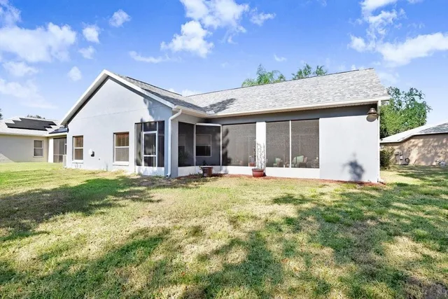 a backyard of a house with table and chairs and potted plants