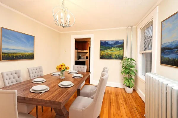 a view of a dining room with furniture wooden floor and a chandelier