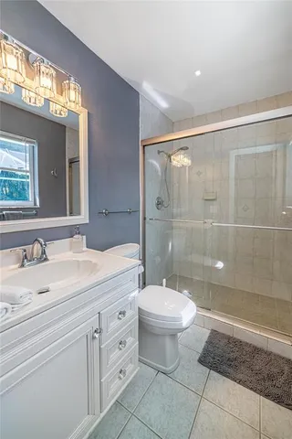 a spacious bathroom with a shower sink vanity mirror and toilet