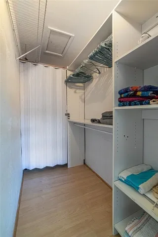 a view of walk in closet with clothes and shoes
