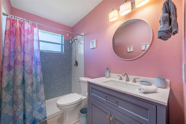 a bathroom with a sink vanity mirror and toilet