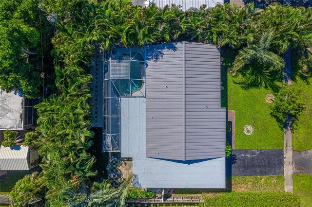 a view of house with a yard and potted plants