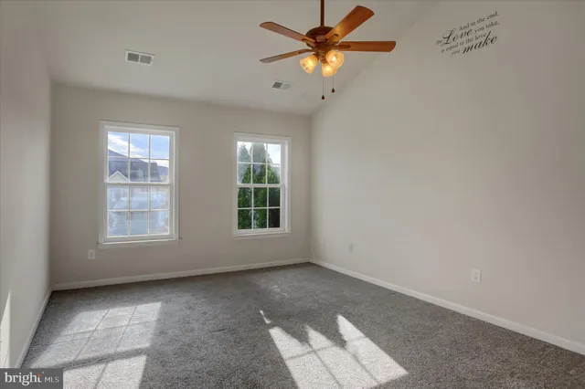 an empty room with a window and a fan