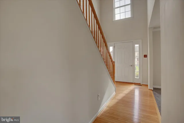 a view of a hallway with wooden floor and staircase