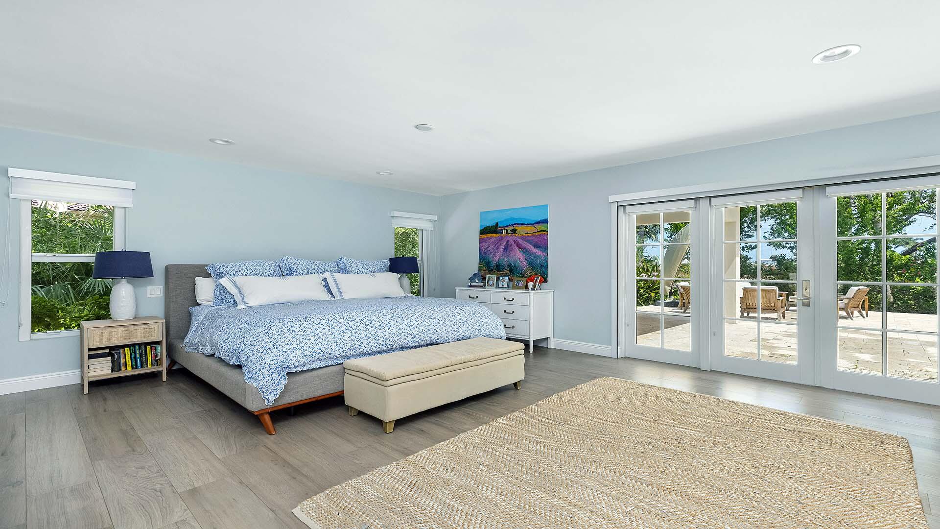 335 Old School Road Gulf Stream, FL 33483 - Photo 16 of 29 a bedroom with a large bed and wooden floor