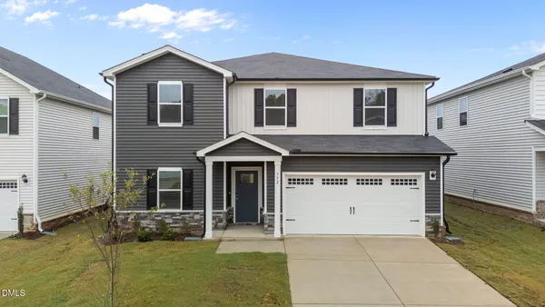 a front view of a house with a yard and garage