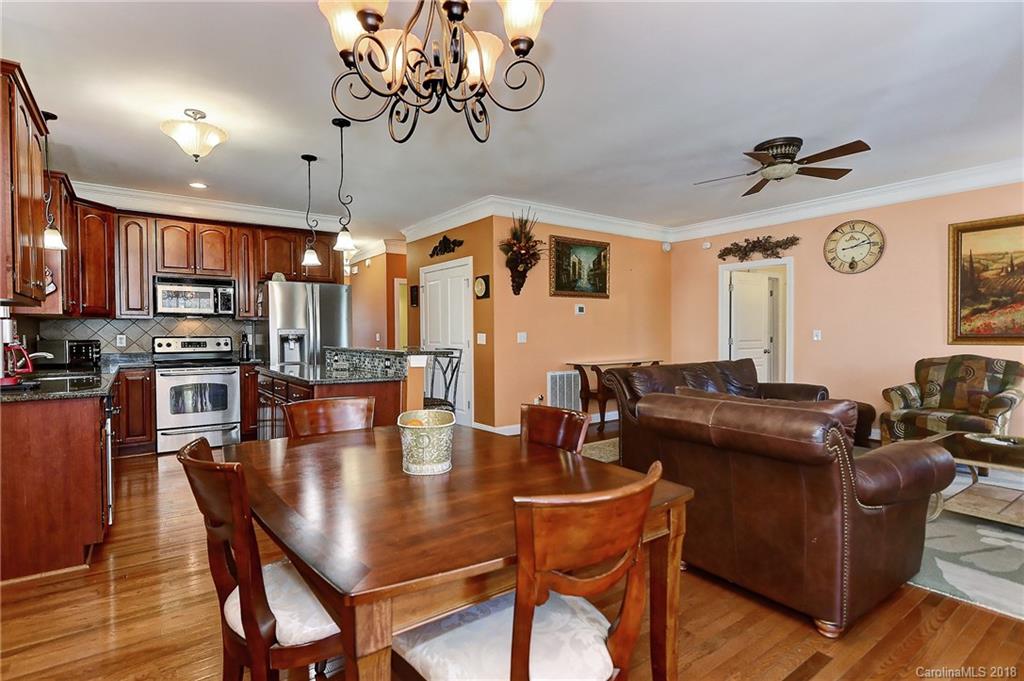 4172 Sunset Ridge Drive Rock Hill, SC 29732 - Photo 11 of 35 a dining room with wooden floor a chandelier a wooden table and chairs