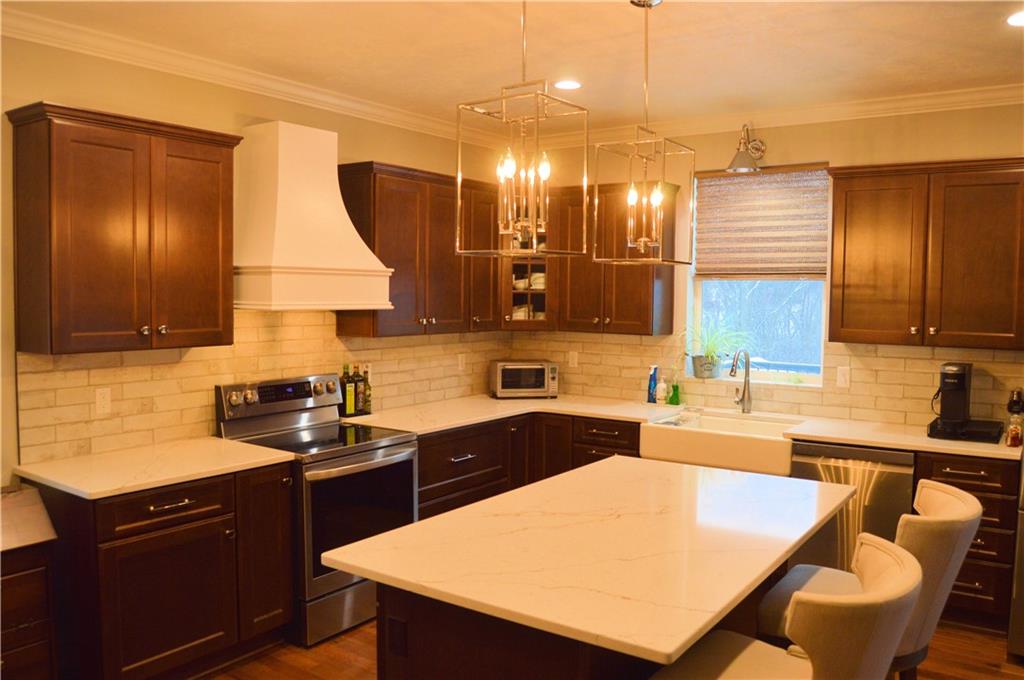 2169 Lovi Road Freedom, PA 15042 - Photo 10 of 25 a kitchen with a sink a stove a kitchen island and chairs