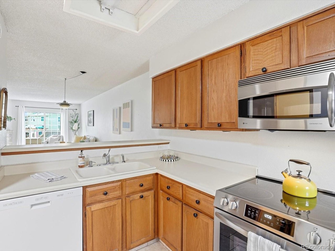 1818 South Quebec Way, Unit 2 Denver, CO 80231 - Photo 5 of 16 a kitchen with stainless steel appliances a stove a sink and cabinets