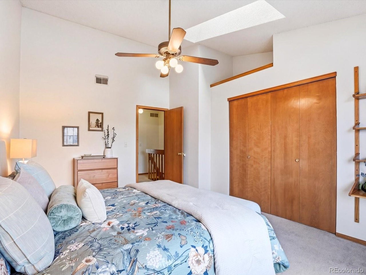 1818 South Quebec Way, Unit 2 Denver, CO 80231 - Photo 10 of 16 a bedroom with a large bed and a chandelier