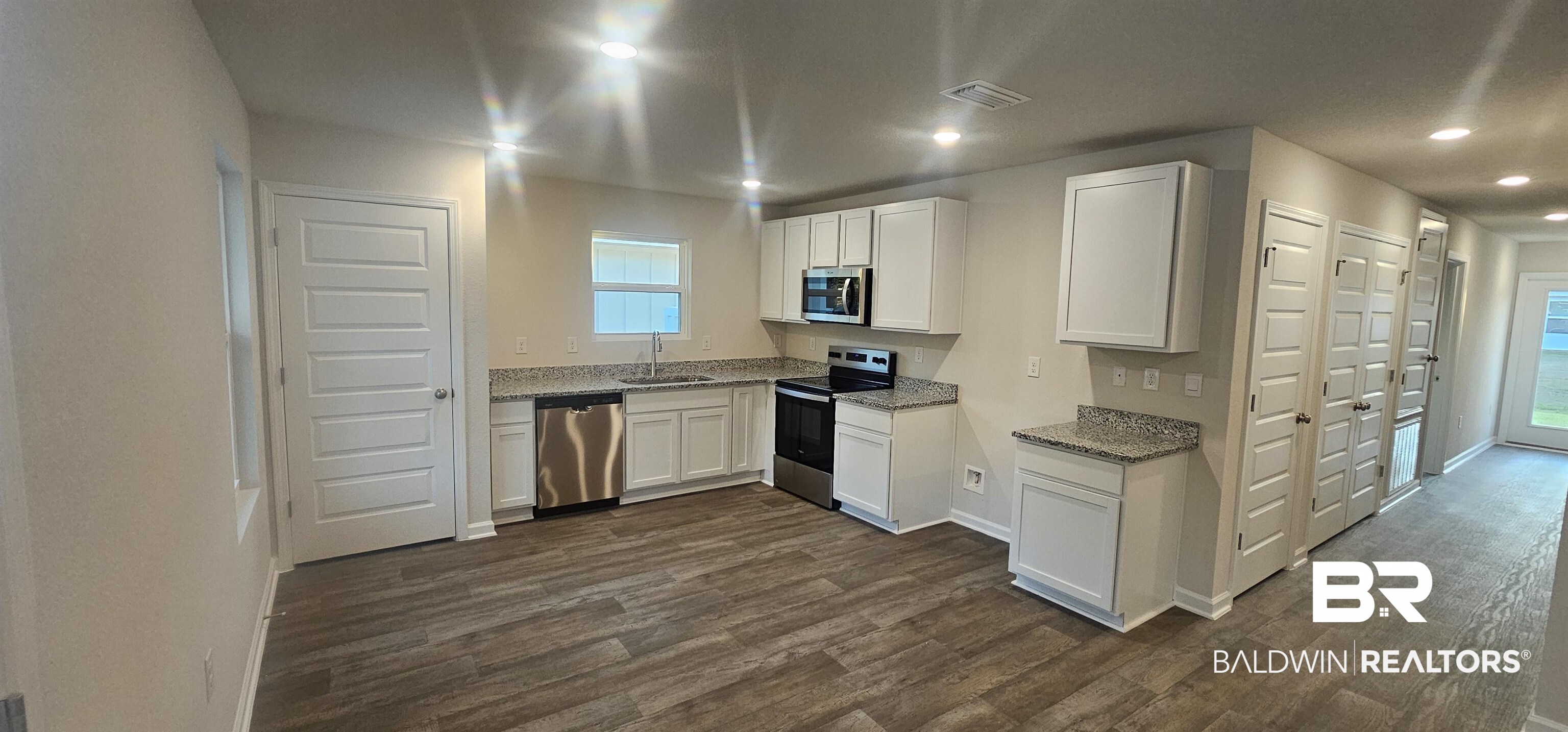 1004 South Bay Street Foley, AL 36535 - Photo 7 of 32 Kitchen with white cabinetry, sink, dark hardwood / wood-style floors, and stainless steel appliances